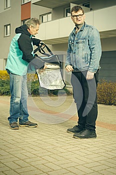 Customer assuming a pizza food from a delivery man on sidewalk