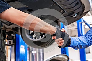 Customer and auto service mechanic shake hands. Car repair and maintenance