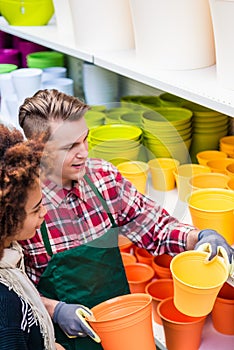 Customer buying plastic pots at the advice of a helpful worker