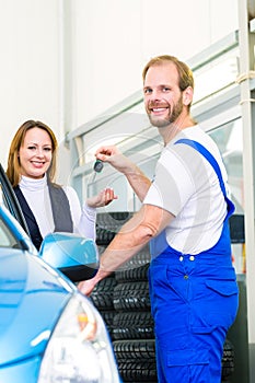 Customer and car mechanic in auto workshop