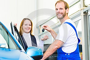 Customer and car mechanic in auto workshop