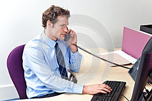 Customer care worker in an office on the telephone