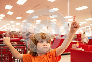 Customer child holdind trolley, shopping at supermarket, grocery store. Supermarket, Shopping with Child.