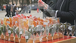 Customer choosing sweet sugar lollipops at store