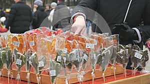 Customer choosing sweet sugar lollipops at store