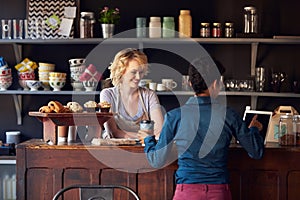 Customer In Coffee Shop Ordering Using Digital Tablet