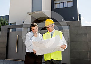 Customer and constructor foreman worker talking on new house building blueprints in real state business concept