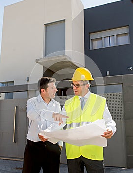 Customer and constructor foreman worker talking on new house building blueprints in real state business concept