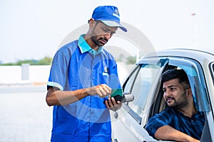 Customer doding payement using creadit card at petrol pump or gas filing station - concept of cashless transaction