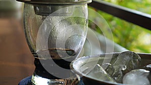 Customer drinks ice tea waits brewing black coffee using a Vietnamese Traditional phin Filter in cafe. Coffee drips
