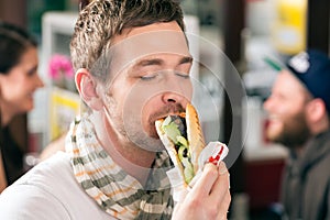 Customer eating Hotdog in fast food snack bar