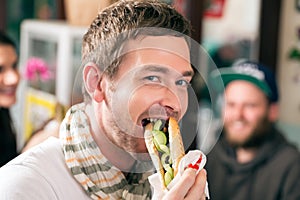 Customer eating Hotdog in fast food snack bar