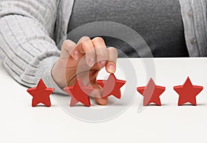 Customer experience feedback concept. Five red stars, the best rating of excellent services with a female hand to meet. White