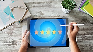 Customer experience satisfaction, feedback, review. Stars icon on device screen.