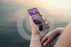 Customer Experiences Concept. Five Stars Rating and Positive Review show on Smartphone`s Screen. Modern Woman Reading Client