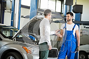 Customer giving him car keys to mechanic