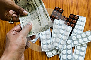 Customer giving money to buy drug at drugstore pharmacy. Close up view. Various capsules, tablets, Pills in medicine shop on table