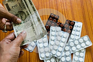 Customer giving money to buy drug at drugstore pharmacy. Close up view. Various capsules, tablets, Pills in medicine shop on table