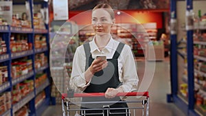 Customer goes with shopping cart checking shopping list