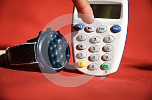 Customer is going to press the buy button on a bank e-card reader machine for onlineshopping from Home