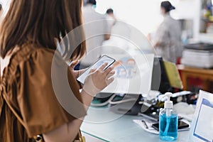 Customer hand scanning qr code for cashless payment at retail shop.