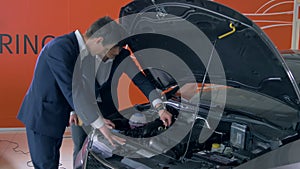 Customer inspecting car engine