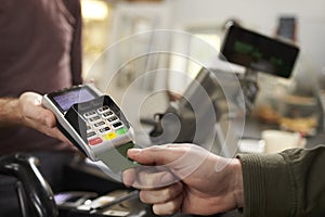 Customer makes credit card payment over counter at a cafe photo