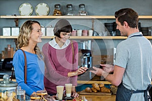 Customer making payment through payment terminal at counter