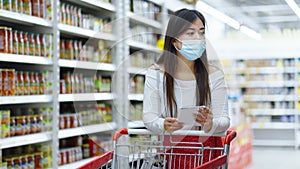Customer in mask choosing food according to shopping list