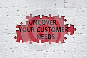 Customer Needs symbol. White puzzle with words Uncover your Customer Needs. Beautiful red background. Business concept. Copy space