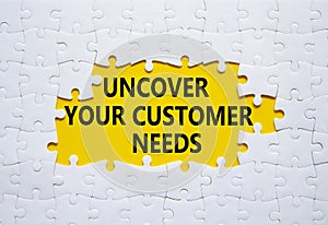 Customer Needs symbol. White puzzle with words Uncover your Customer Needs. Beautiful yellow background. Business concept. Copy
