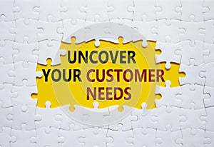 Customer Needs symbol. White puzzle with words Uncover your Customer Needs. Beautiful yellow background. Business concept. Copy