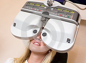 Customer of a optometrist or optician looking through phoropter