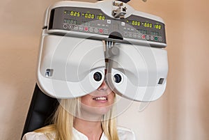 Customer of a optometrist or optician looking through phoropter