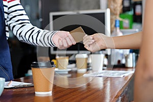 Customer paying coffee by credit, debit electronic card at cafe