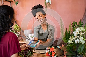 Customer paying with contactless credit card at flower shop