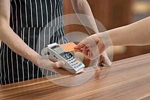 Customer is paying with contactless credit card in shop