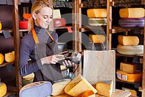 Customer paying for order of cheese in grocery shop.