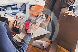 Customer paying for order of cheese in grocery shop.