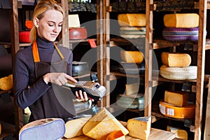 Customer paying for order of cheese in grocery shop.