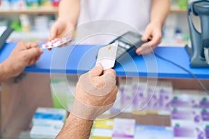 Customer paying for pills using credit card.