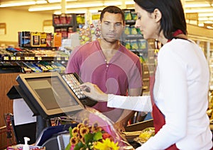 Customer Paying For Shopping At Supermarket Checkout