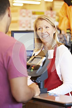 Customer Paying For Shopping At Supermarket Checkout