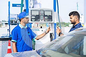 customer paying to worker at pertrol bump by scanning QR code using mobile phone after refuling car - concept of digital
