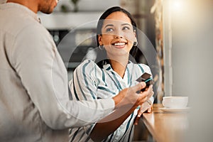 Customer paying using contactless credit card, standing by cafe or restaurant bar counter. Smiling woman make cashless