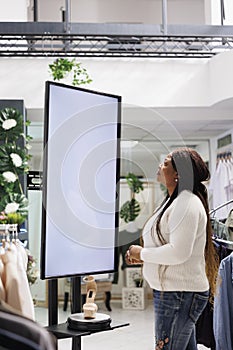 Customer reading information on board showcasing shoes for sale