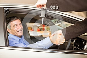 Customer receiving car keys while shaking hand