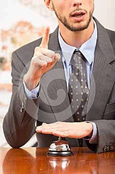 Customer ringing hotel bell at reception desk