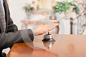 Customer ringing hotel bell at reception desk