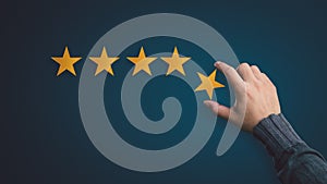 Customer satisfaction concept. hand put the stars to complete five stars. with copy space.giving a five star rating. Service